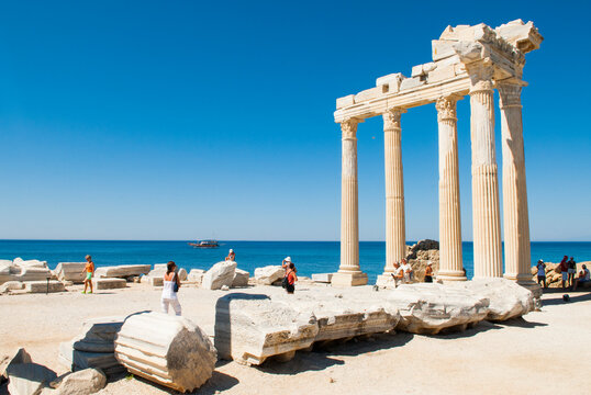Visitors explore the ancient Temple of Apollo at the archaeological site of Side near the coast in Antalya Turkey on a sunny day