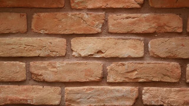 A close-up view of weathered brick wall showing its textured surface and rustic appearance, slow motion camera movement across ancient masonry