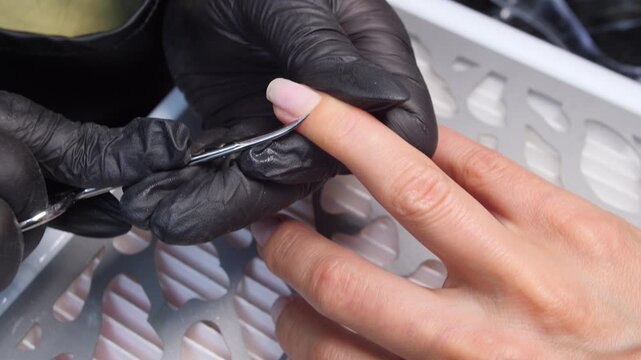 A woman's hand during a manicure. A woman getting a manicure. A manicurist is doing a client's nails at a nail salon. Beauty salon concept: manicures, pedicures.