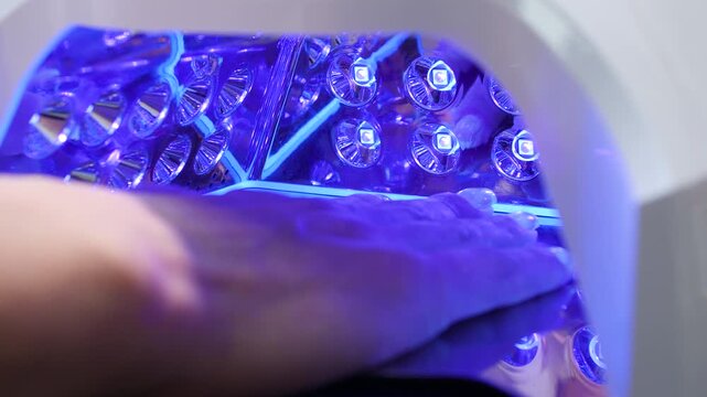 A woman's hand during a manicure. A woman getting a manicure. A manicurist is doing a client's nails at a nail salon. Beauty salon concept: manicures, pedicures.