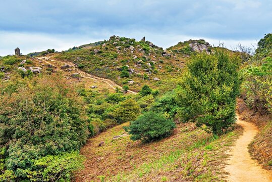 Explore Lo Fu Tau Country Trail on Lantau Island in Hong Kong while enjoying nature and the rocky landscape under the cloudy sky
