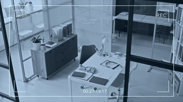 CCTV shot of empty medical office with stethoscope on desk being monitored by security camera. Clip is ideal for healthcare facility surveillance and clinic security system commercials