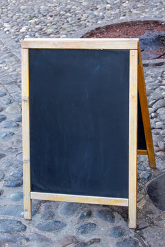 Blank empty black board outside on urban street