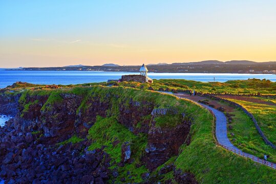 Coastal view at Seopjikoji during magic hour with grassy cliffs and ocean in Jeju Island, South Korea