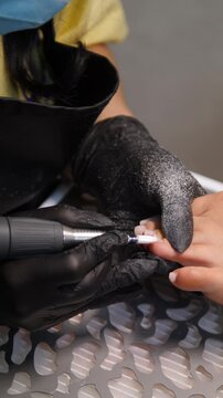 A woman's feet during a pedicure. Woman getting pedicure in beauty salon, closeup. A pedicurist working at a beauty salon. Beauty salon concept: pedicures - Vertical video
