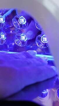 A woman's hand during a manicure. A woman getting a manicure. A manicurist is doing a client's nails at a nail salon. Manicure services - Vertical video
