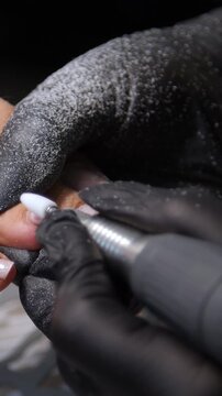 A woman's feet during a pedicure. Woman getting pedicure in beauty salon, closeup. A pedicurist working at a beauty salon. Beauty salon concept: pedicures - Vertical video