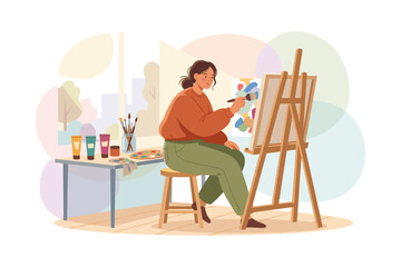 Fototapeta premium Woman artist painting on canvas at easel in studio with art supplies