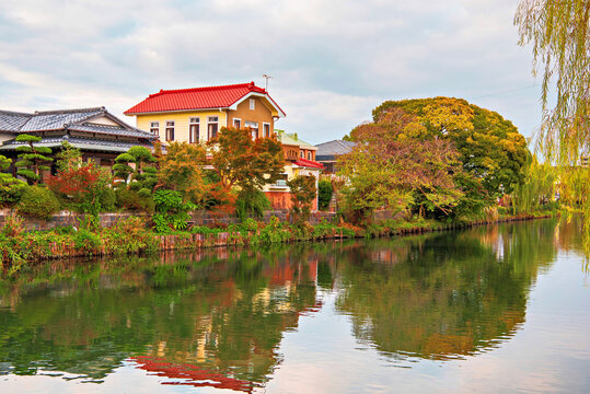 Autumn colors reflect on Yanagawa Canal in soft lighting during magic hour in Fukuoka, Kyushu, Japan
