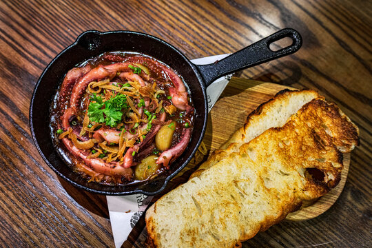 Octopus in spicy sauce served with toasted bread for a seafood meal in Vietnam