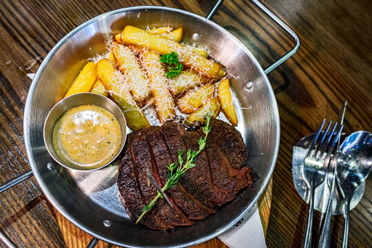 Medium Wagyu steak served with potato wedges and cheese in a restaurant in Vietnam