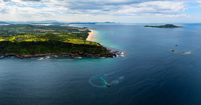 Fishing for anchovies with traditional nets in Tuy An, Phu Yen Province in Vietnam with boats dotting the coastline and islands in view