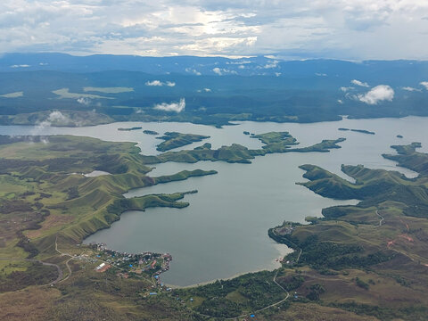 Aerial view of the beautiful Sentani Lake and its surrounding green hills in Jayapura, Papua, Indonesia