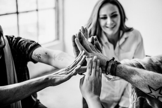 Diverse group high-fiving in teamwork celebration