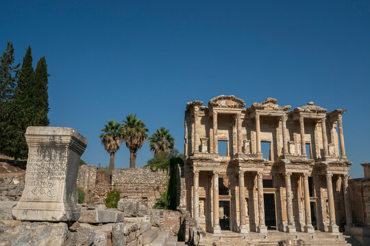 Exploring the ancient Celcus Library at Ephesus archaeological site in Turkey with palm trees in the background