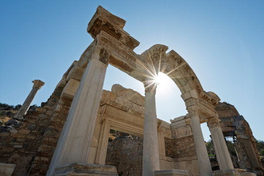 Explore Temple of Hadrian at Ephesus archaeological site in Turkey with clear blue sky and sunlight highlighting the ruins