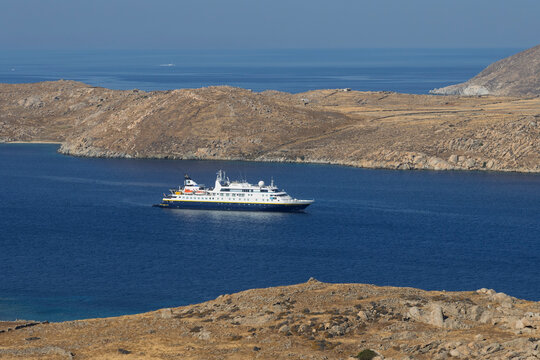National Geographic Orion expedition ship navigates the waters near Delos archaeological site in the Cyclades archipelago, Greece