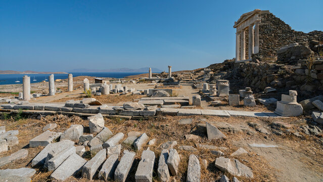 Exploring the ruins of the Temple of Isis at Delos archaeological site in Greece during a sunny day in the Cyclades archipelago