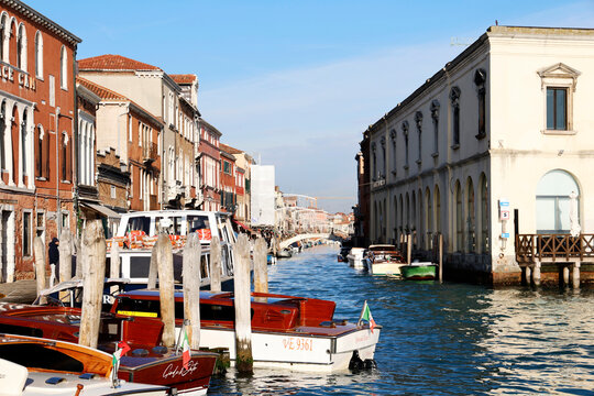Exploring streets and canals in Murano with boats and historic buildings