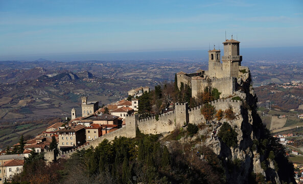 Historic towers and stone walls rise above the landscape in the City of San Marino at Monte Titano during a sunny day in autumn