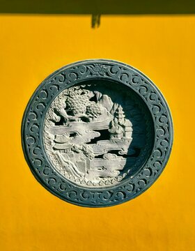 The yellow wall relief, characteristic East Asian architecture of an old temple (Faxi Temple, Hangzhou, China)
