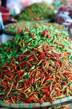 Chili peppers for sale at a market in Luang Prabang, Laos with various colors and sizes displayed in baskets