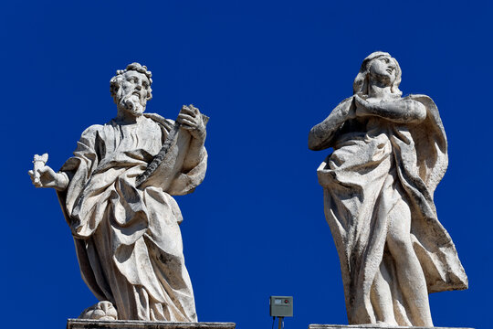 Rooftop statues of apostles hold parchment and display faith above the city in Italy