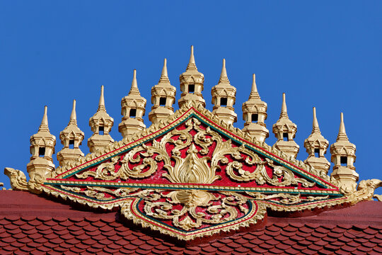 Golden decorative motifs on the roof of Wat Manorom temple in Luang Prabang, Laos, showcasing intricate craftsmanship and design