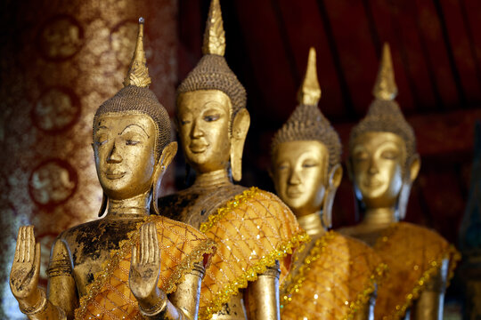 Golden Buddha statues on the main altar at Wat May Souvannapoumaram in Luang Prabang, Laos display traditional craftsmanship and cultural heritage
