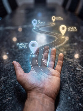 Business growth roadmap concept with a glowing holographic road path rising from a human hand, representing strategic planning and future success
