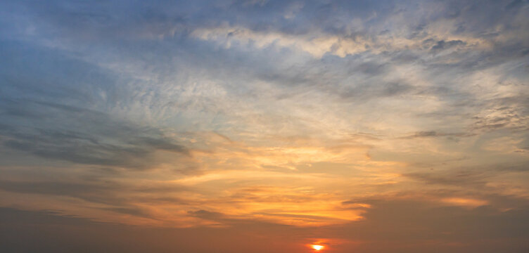 Dramatic sunset sky with glowing clouds and warm evening atmosphere