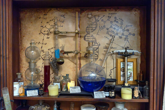 Collection of lab equipment and old notes in a dark wooden cabinet