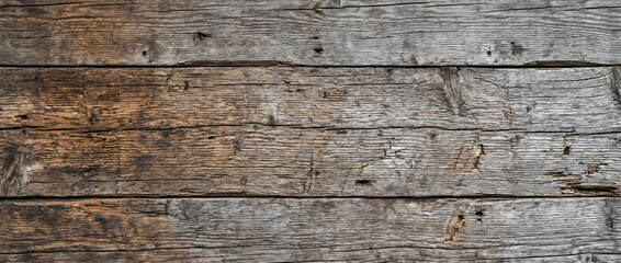 Weathered wood boards reveal deep rough grooves splitting cracks and a striking contrast between gray and brown aged tones © MDAzizur
