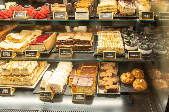 Display of various desserts in a bakery case showing cakes, cookies, and pastries at a local shop