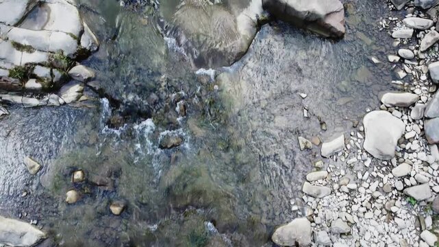 Water flow in mountain river in overcast day, aerial view