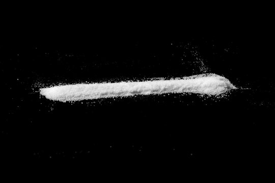 a strip of white powder isolated on a black background