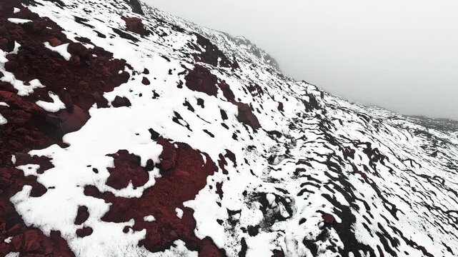 Snow Covered Volcanic Mountain Ridge in Ecuador Andes, Foggy High Altitude Landscape, Black Rocks and Dramatic Paramo Wilderness Scene