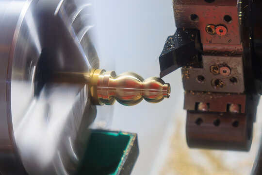 High-precision CNC lathe machine performing a forming cut on a brass material shaft part.