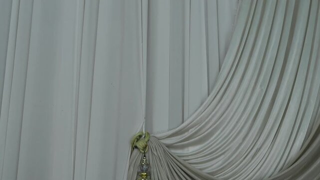 Gold tie-back curtains featuring tassels and crystal-like accents for a luxurious look.
