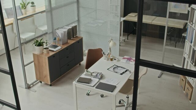 High angle no people shot of empty modern medical office showing desk with stethoscope and tablet. Video suitable for healthcare marketing, clinic promotions, or medical services advertising