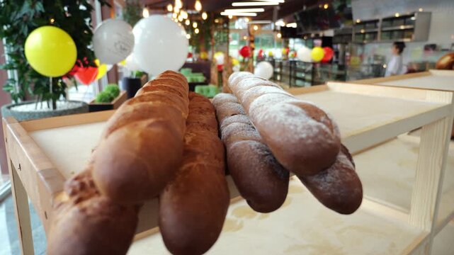 A close-up of a freshly baked baguette on the shelf of a store or bakery. Delicious bread. The concept of public catering. 