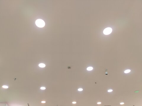 Modern recessed LED downlight panels on ceiling background