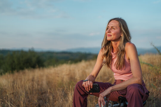 Woman hiking in nature enjoying peaceful sunset view