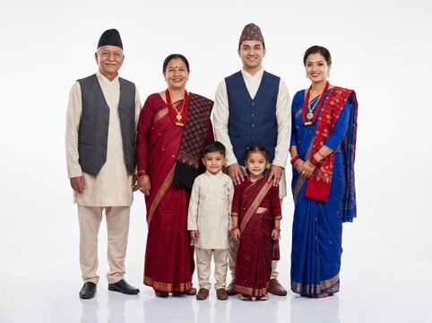 Happy Multigenerational Nepali Family Standing Together in Traditional Clothing on White Background