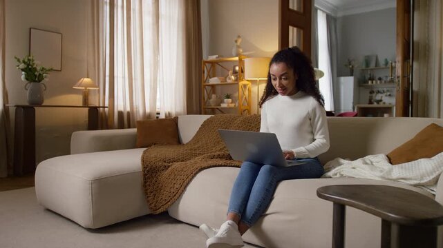 Woman Using Laptop on Sofa at Home