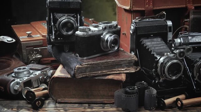 Old cameras in a composition on a wooden background, slowly moving in a horizontal plane.