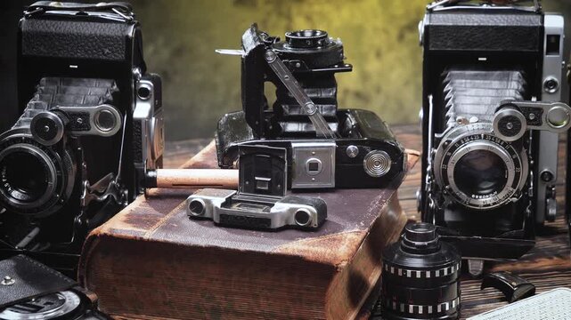 Old cameras in a composition on a wooden background, slowly moving in a horizontal plane.