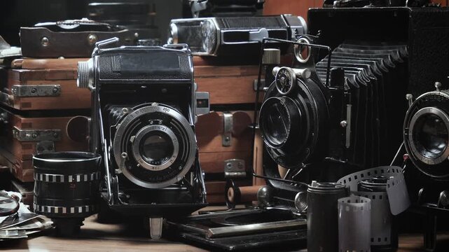 Old cameras in a composition on a wooden background, slowly moving in a horizontal plane.