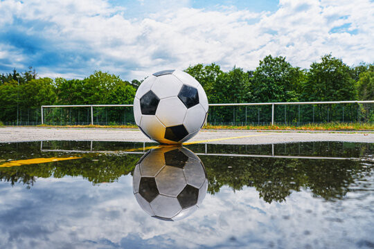 soccer ball with a reflection in a puddle - center, midfield