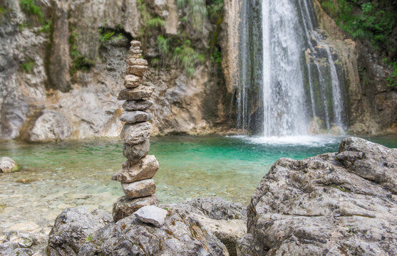the pebbles stacked in front of a waterfall in rocky mountain  a symbol of balance and zen life